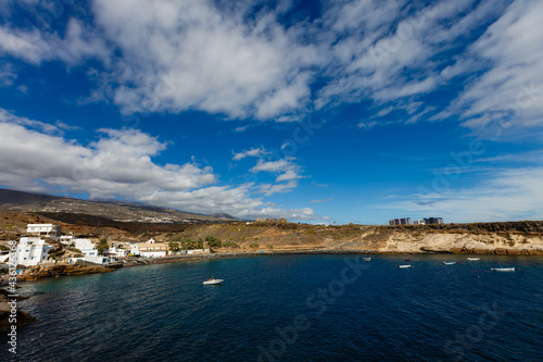 Tropical island of Tenerife. The coast of a Spanish city on the Atlantic ocean. Panorama of the city and beach on the island of Tenerife. Background color with gradient and grain, sound effect