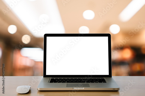 Front view of the laptop on the work desk in the office blur background.
