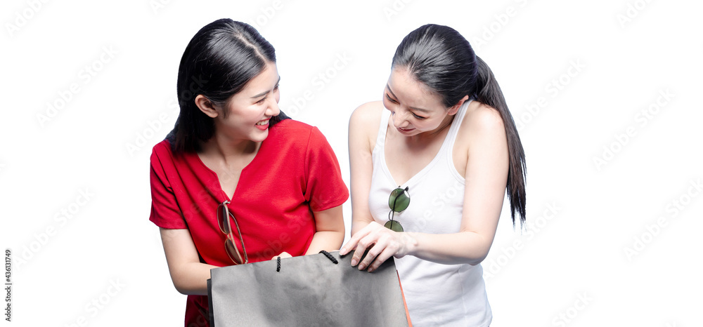Portrait of smiling couple asian women holding shopping bags isolated on white background with clipping path. Two cheerful pretty young girls shopping together, holding sale bags Portrait of smiling couple asian women holding shopping bags isolated on white background with clipping path. Two cheerful pretty young girls shopping together, holding sale bags
