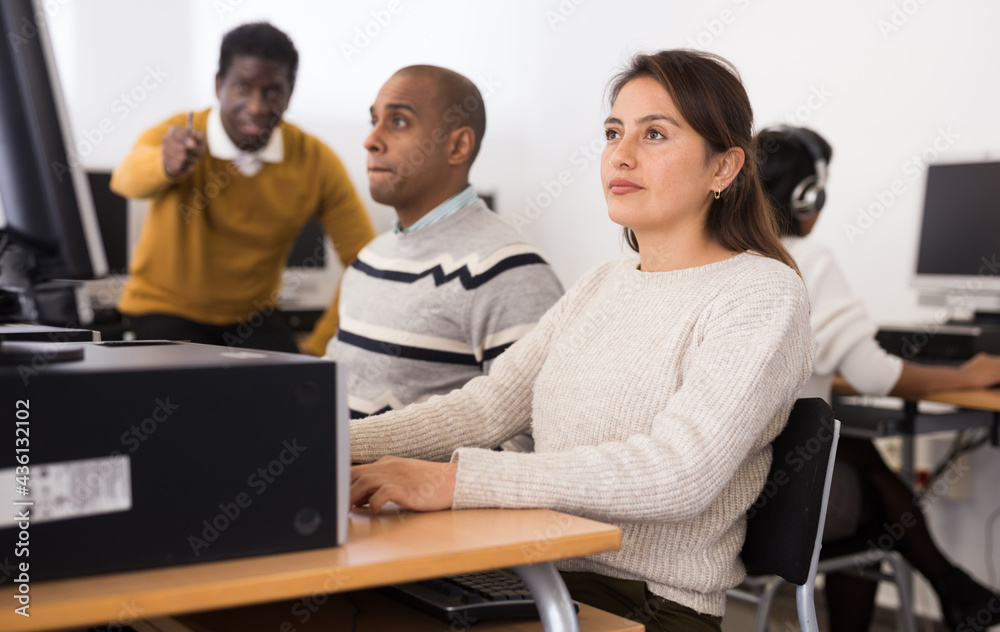 Fototapeta premium Intelligent young Latina engaged in self-learning working with computer in public library