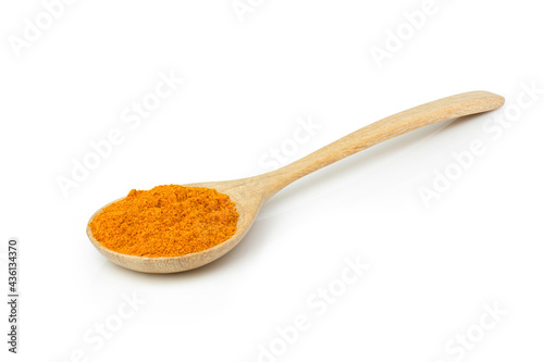 Turmeric powder in wooden spoon on white.