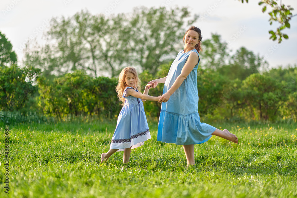Fototapeta premium nature scene with family outdoor lifestyle. Mother and little daughter playing together in a park. Happy family concept. Happiness and harmony in family life.
