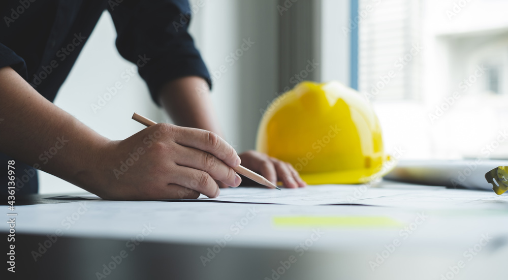Architects or engineers working construction and drawing construction plans, printing, writing on-site construction sites. Home design concept
