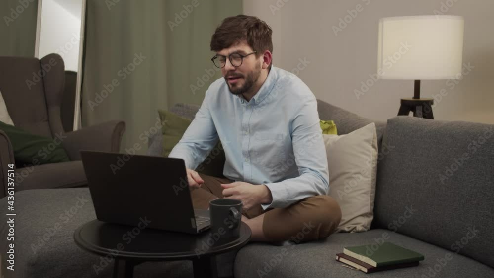 An aggressive European man talks to someone on a video call on a computer. An aggressive European man talks to someone on a video call on a computer.