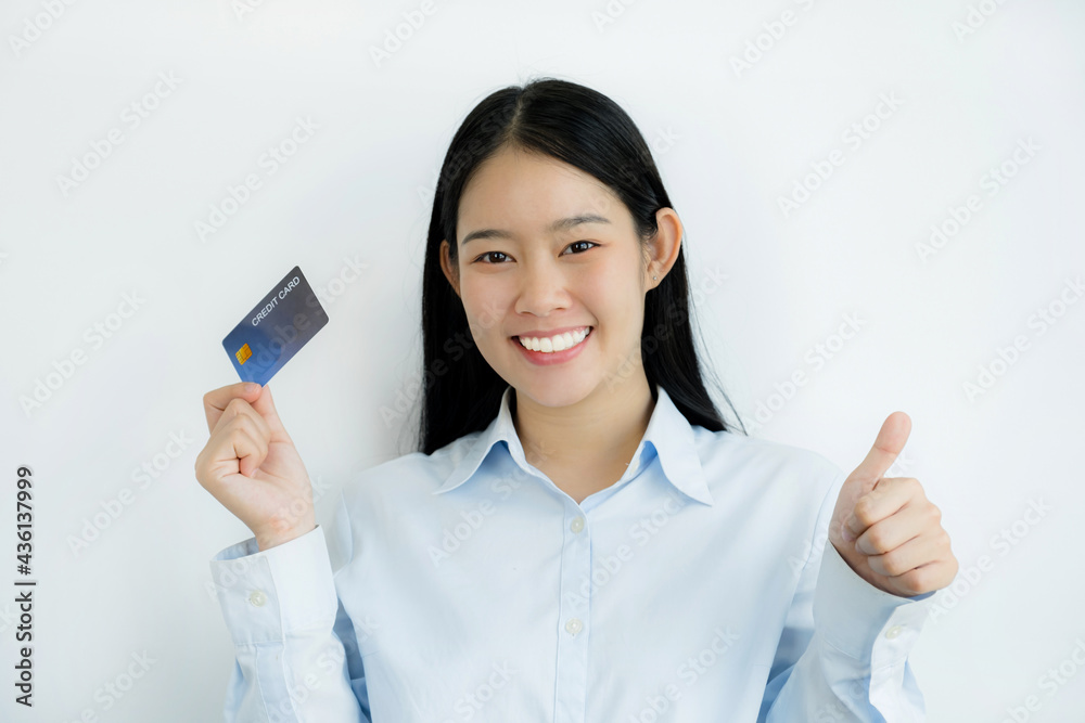 Portrait of a lovely young Asian beautiful woman with long hair holding a blue credit card, her eyes sparklingly at the camera. Ready to pay shopping according to discounted products Portrait of a lovely young Asian beautiful woman with long hair holding a blue credit card, her eyes sparklingly at the camera. Ready to pay shopping according to discounted products