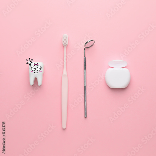 Dental mirror with toothbrush  floss and funny tooth on color background