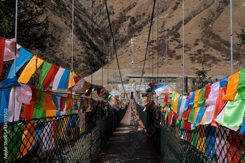 colorful Buddhist prayer flags on both sides of the bridge with Mountain background © Weewie