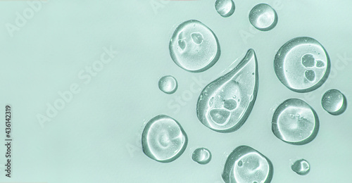 Fotografia a Aloe vera drops of liquid gel serum , texture micro bubble on green background, beauty concept, horizontal banner