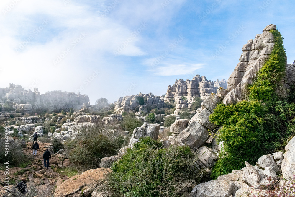 a view of tourists walking around the weather eroded peaks and valleys of Torcal in Antequera
