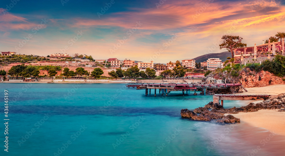 Colorful spring sunset in Ksamil town. Amazing evening seascape if Ionian sea. Exciting outdoor scene of Butrint National Park, Albania, Europe. Traveling concept background..