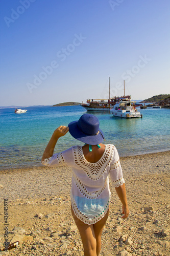 beautiful young woman in a blue hat on the beach