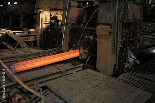 red hot steel bars are being rolled to different sizes in a rolling mill