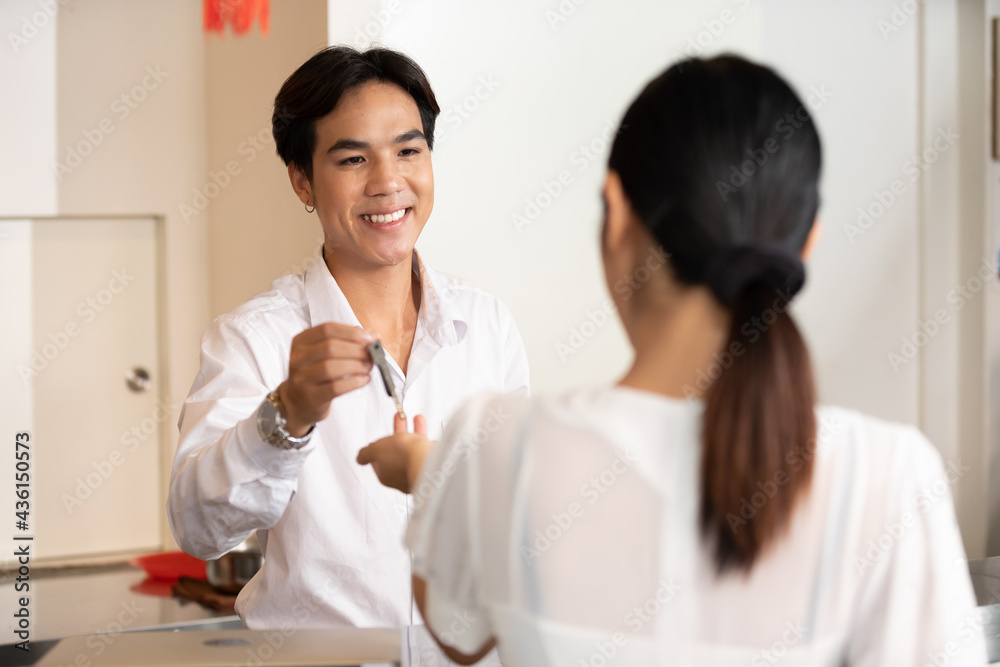 male receptionist or hotel front desk smiling and giving keycard to a customer male receptionist or hotel front desk smiling and giving keycard to a customer