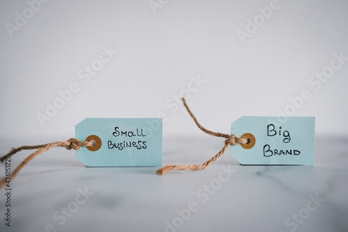 product tags with small business vs big brand texts side by side at shallow depth of field, supporting small businesses