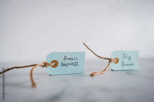 product tags with small business vs big brand texts side by side at shallow depth of field, supporting small businesses