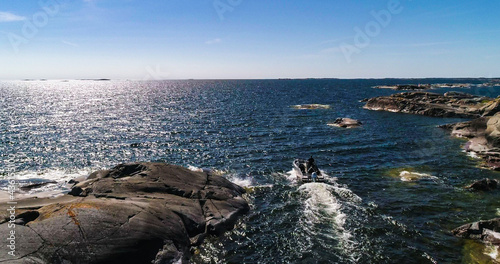 Boat leaving a rocky island photo