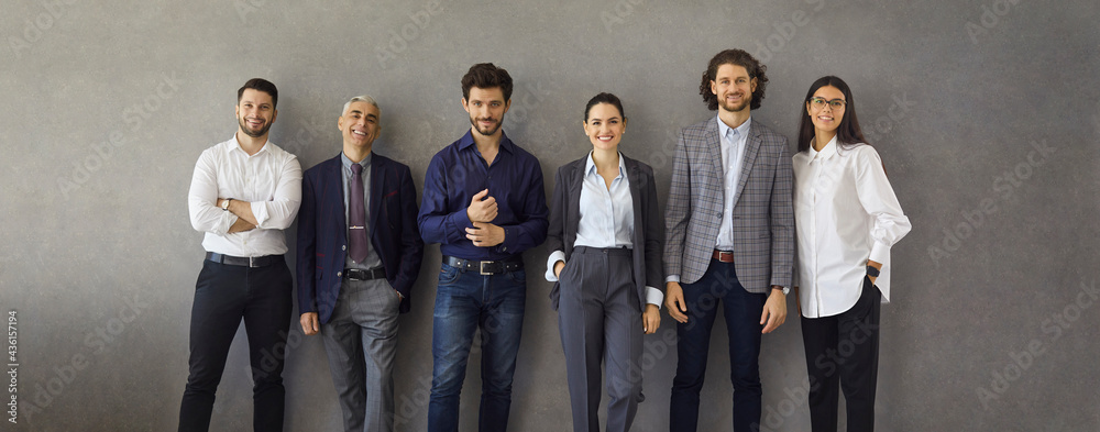 Team of happy satisfied business people standing leaning on grey concrete wall. Banner with group portrait of successful stylish business professionals, entrepreneurs, colleagues, company coworkers - obrazy, fototapety, plakaty 