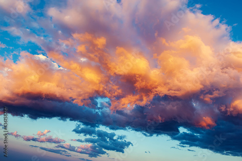 Cumulus clouds with bright illumination of sunset or dawn. Dramatic skyscape