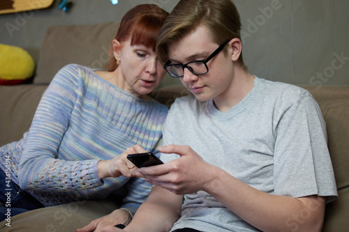 Mother son teenager talking at home family relationship on the couch. High resolution photos