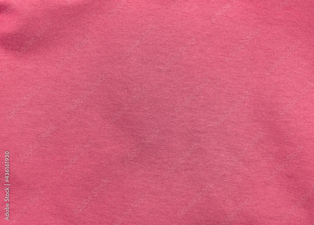 Fototapeta premium Pink jersey fabric matte texture top view. Red coral knitwear satin background. Fashion color feminine clothes trend. Female blog backdrop text sign design. Girly abstract wallpaper textile surface.