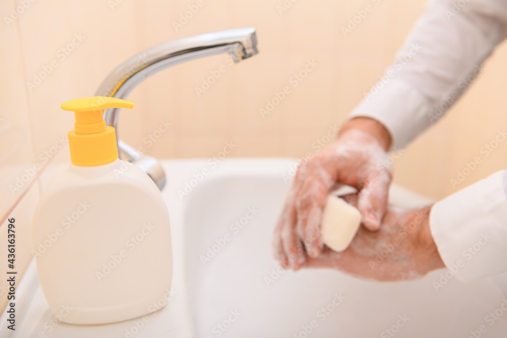 hand washing with soap or gel under running water in the washbasin, cleanliness and hygiene, men's hands dressed in a white shirt hand washing with soap or gel under running water in the washbasin, cleanliness and hygiene, men's hands dressed in a white shirt