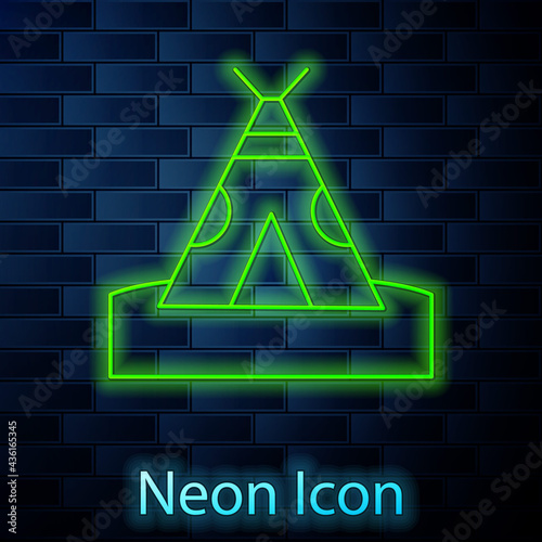 Glowing neon line Traditional indian teepee or wigwam icon isolated on brick wall background. Indian tent. Vector