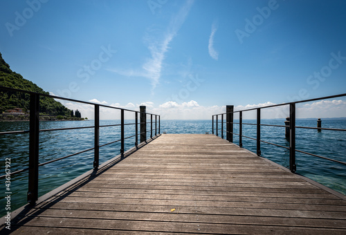 Small empty wooden pier on Lake Garda  Lago di Garda  in front of the small town of Garda  tourist resort in Verona province  Veneto  Italy  southern Europe.