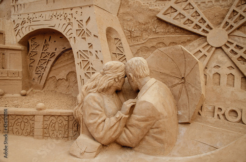 A sculpture of lovers made of sand against the backdrop of the Eiffel Tower. Parisian mood.