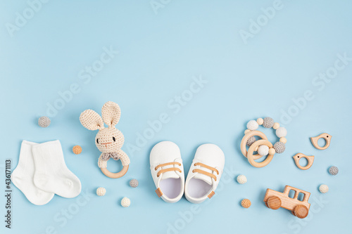 Tableau sur toile Baby shoes, bib and teether on pastel background