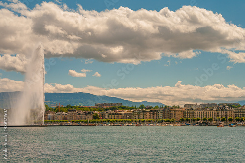 Leman lake at sunset and a super Jet fountain in the historical downtown of Geneva, Switzerland, summer