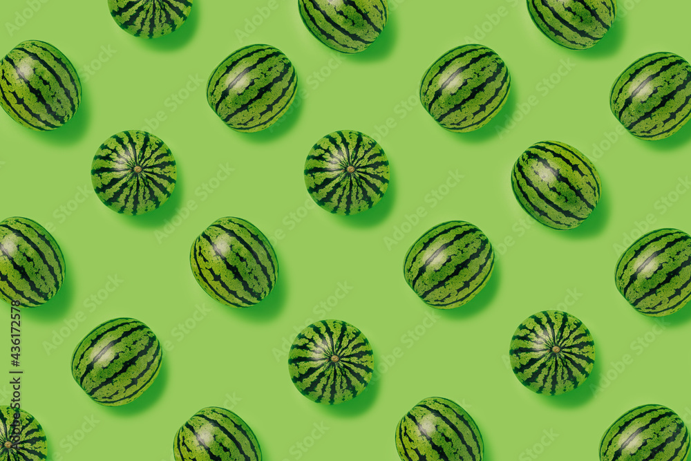 Geometrical pattern of fresh watermelons isolated on a bright green background. Creative food concept. Minimal summer fruit idea. Flat lay, top view. Geometrical pattern of fresh watermelons isolated on a bright green background. Creative food concept. Minimal summer fruit idea. Flat lay, top view.