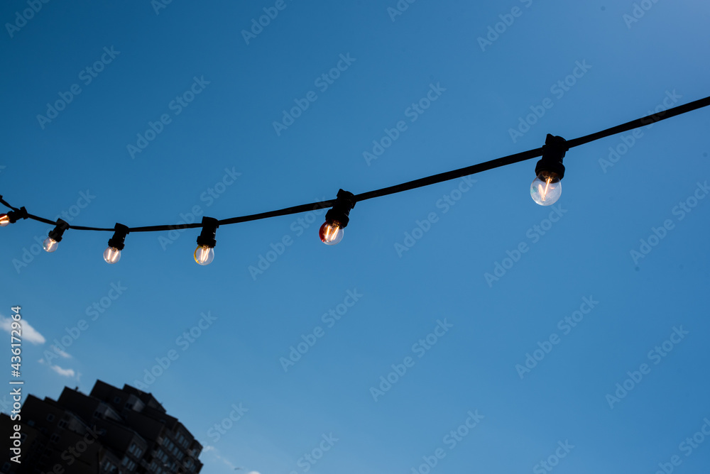 light bulb garland on the blue sky background light bulb garland on the blue sky background