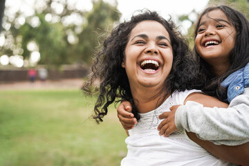 Happy indian mother having fun with her daughter outdoor - Family people and love concept - Focus on mum face