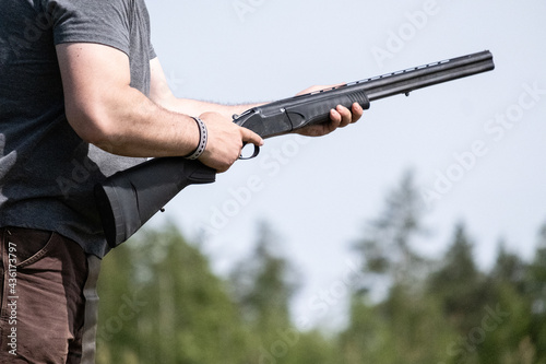 Hunting rifle firing. Hunting in the forest. Hunter loading gun with bullets. A rifle in a man hand, close-up. Russia, Ryazan' 23 may 2021