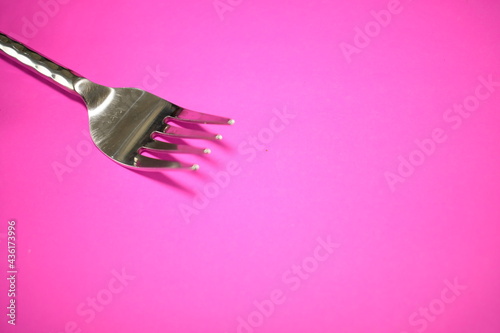 close up silver ware fork on a bright black and pink napkin beautiful abstract
