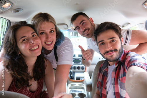 Group of friends taking a selfie into the car before leaving for vacations. Summer adventure. photo