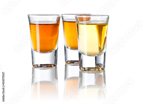Fotografija Three Shot Glasses With Different Spirits on white background