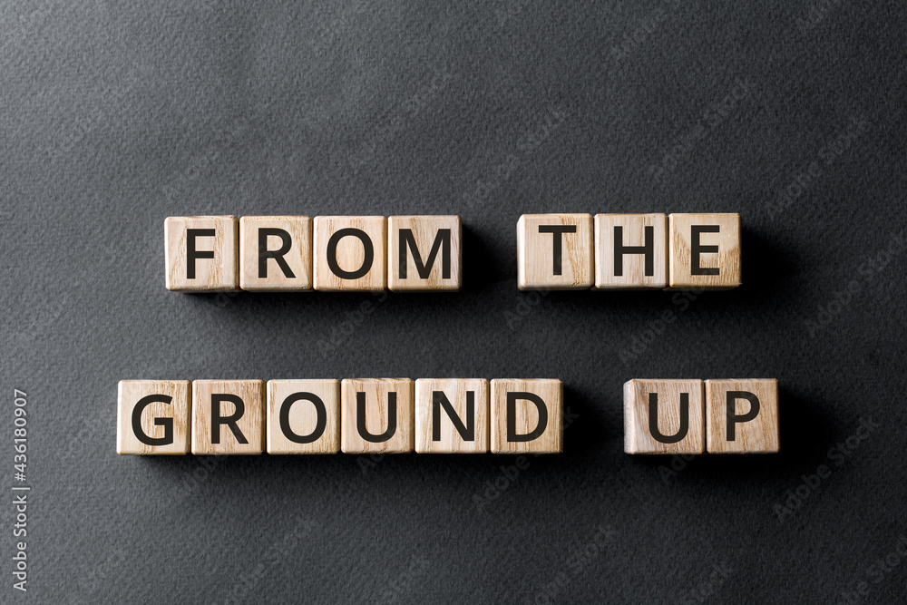 Obraz premium From the ground up - phrase from wooden blocks with letters, from the very beginning concept, gray background