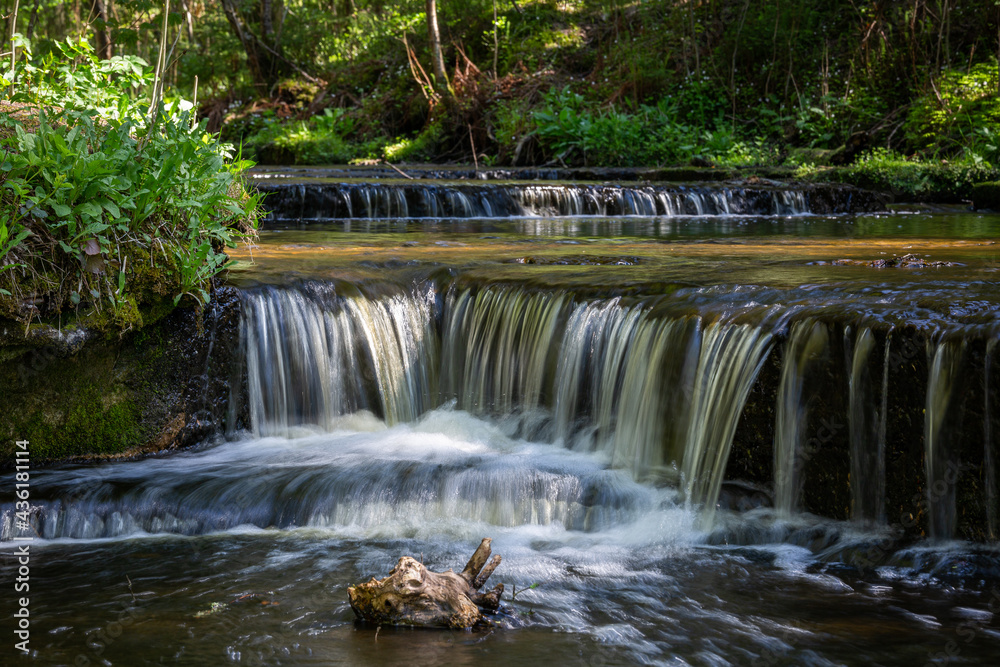 Cascading waterfall cascades in Estonia in green light at summertime Cascading waterfall cascades in Estonia in green light at summertime
