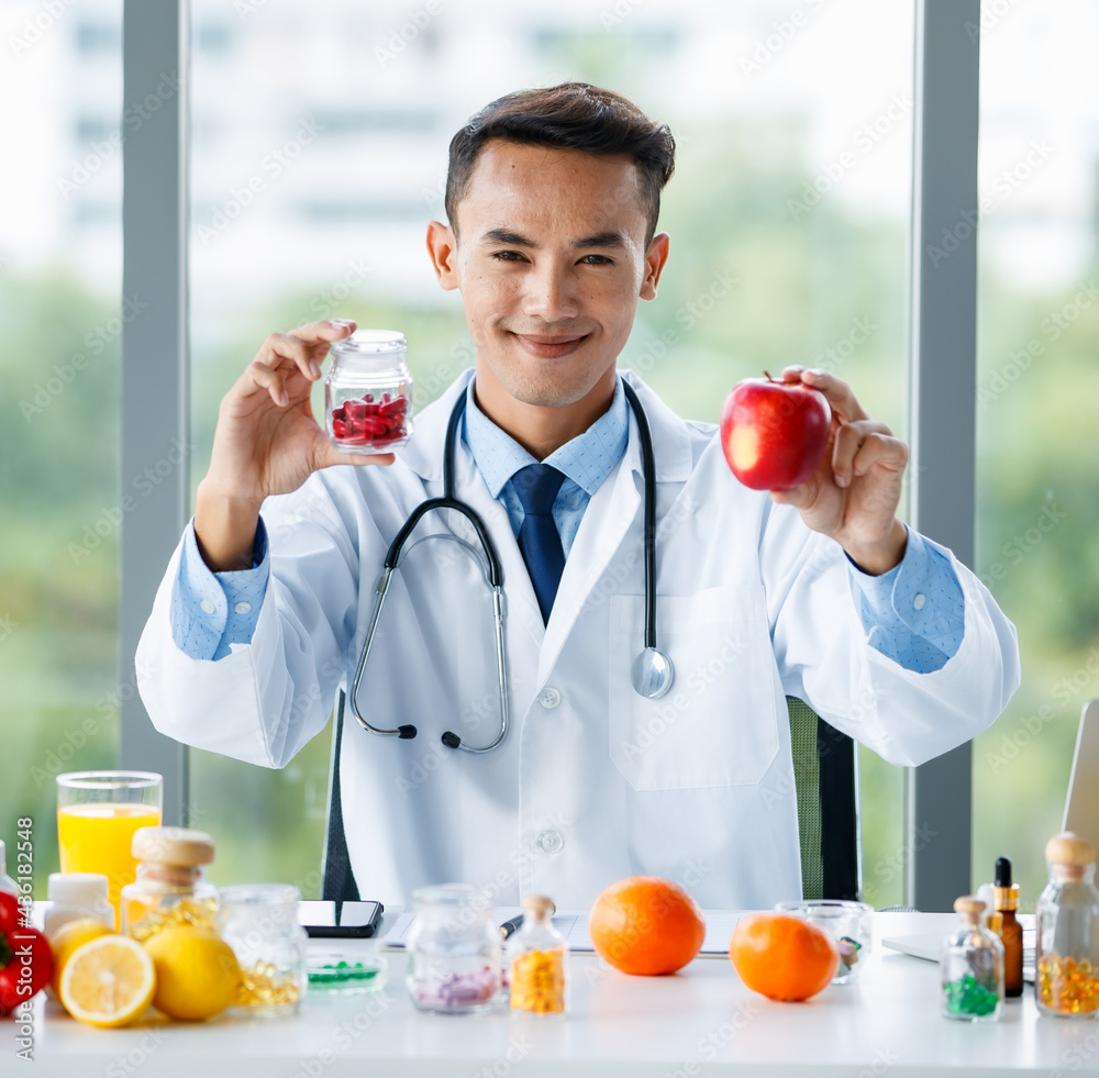 Male nutritionist with fruit and pills in medical office Male nutritionist with fruit and pills in medical office