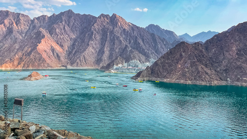 Hatta Dam Lake in mountains enclave region of Dubai, United Arab Emirates is famous tourist attraction with scenery and place to enjoy kayaking boat ride and other water adventure activities. photo