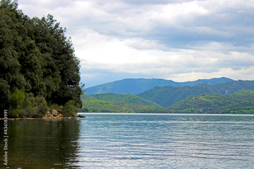 Views of a calm lake surrounded by trees