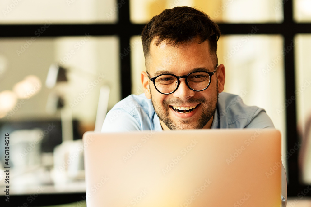Portrait of a businessman working on laptop. Handsome man working in the office Portrait of a businessman working on laptop. Handsome man working in the office