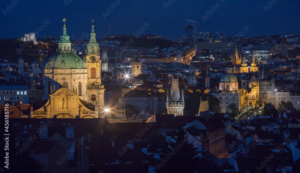evening view of Charles Bridge and the Church of St. Nicholas in Prague