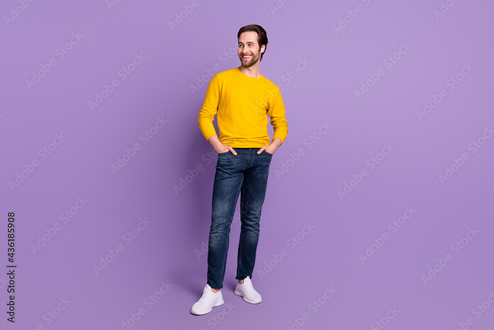 Full length body size photo smiling man in casual clothes looking copyspace isolated pastel purple color background Full length body size photo smiling man in casual clothes looking copyspace isolated pastel purple color background