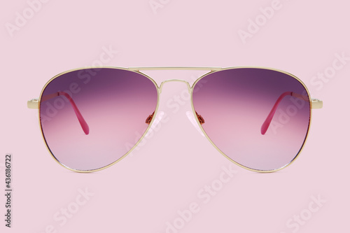sunglasses golden metallic frame and purple polarized lenses isolated on pink background