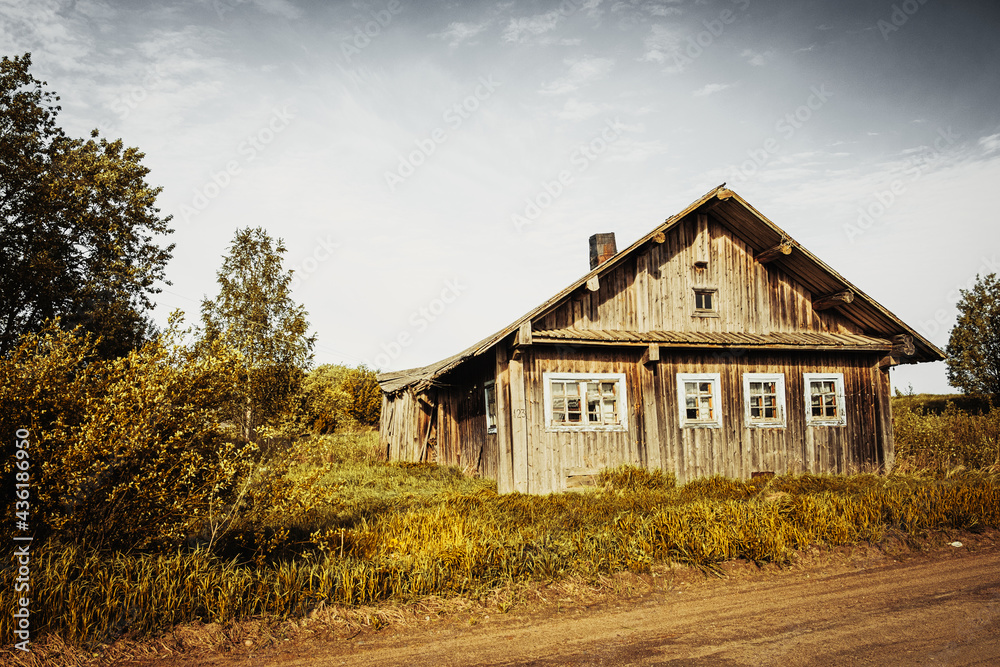 An old, abandoned log house. Deserted village in Russia. A lonely hut without people. Rotten wall construction. Hut against the background of the blue sky. Karelia. Russia. Day. An old, abandoned log house. Deserted village in Russia. A lonely hut without people. Rotten wall construction. Hut against the background of the blue sky. Karelia. Russia. Day.