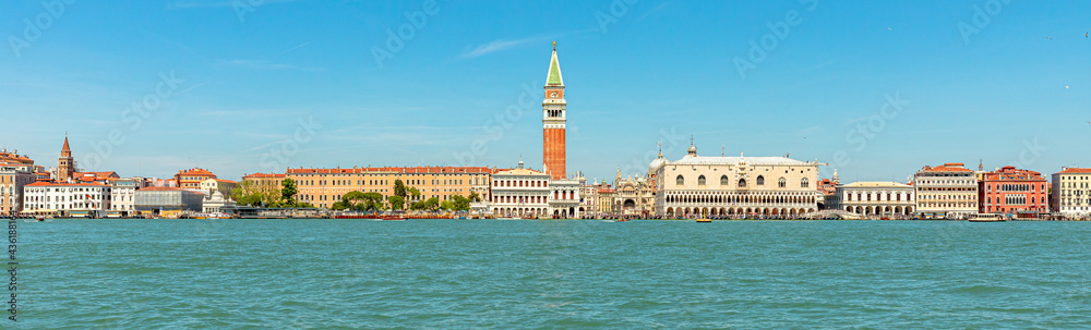 Panorama of San Marco bell tower in San Marco square in Venice with Saint Mark Basilica of Venetian city, Italy. sea view from Giudecca canal by cruise boat trip in Venetian lagoon by ferry boat.