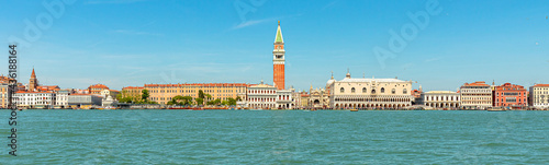 Panorama of San Marco bell tower in San Marco square in Venice with Saint Mark Basilica of Venetian city, Italy. sea view from Giudecca canal by cruise boat trip in Venetian lagoon by ferry boat. © bennymarty