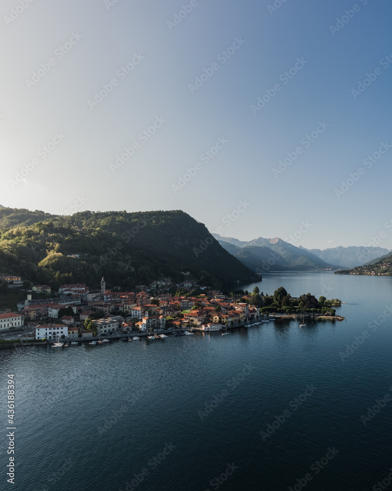 Pella city on lake Orta at sunset seen from the sky. Aerial shot of small village on a lake.